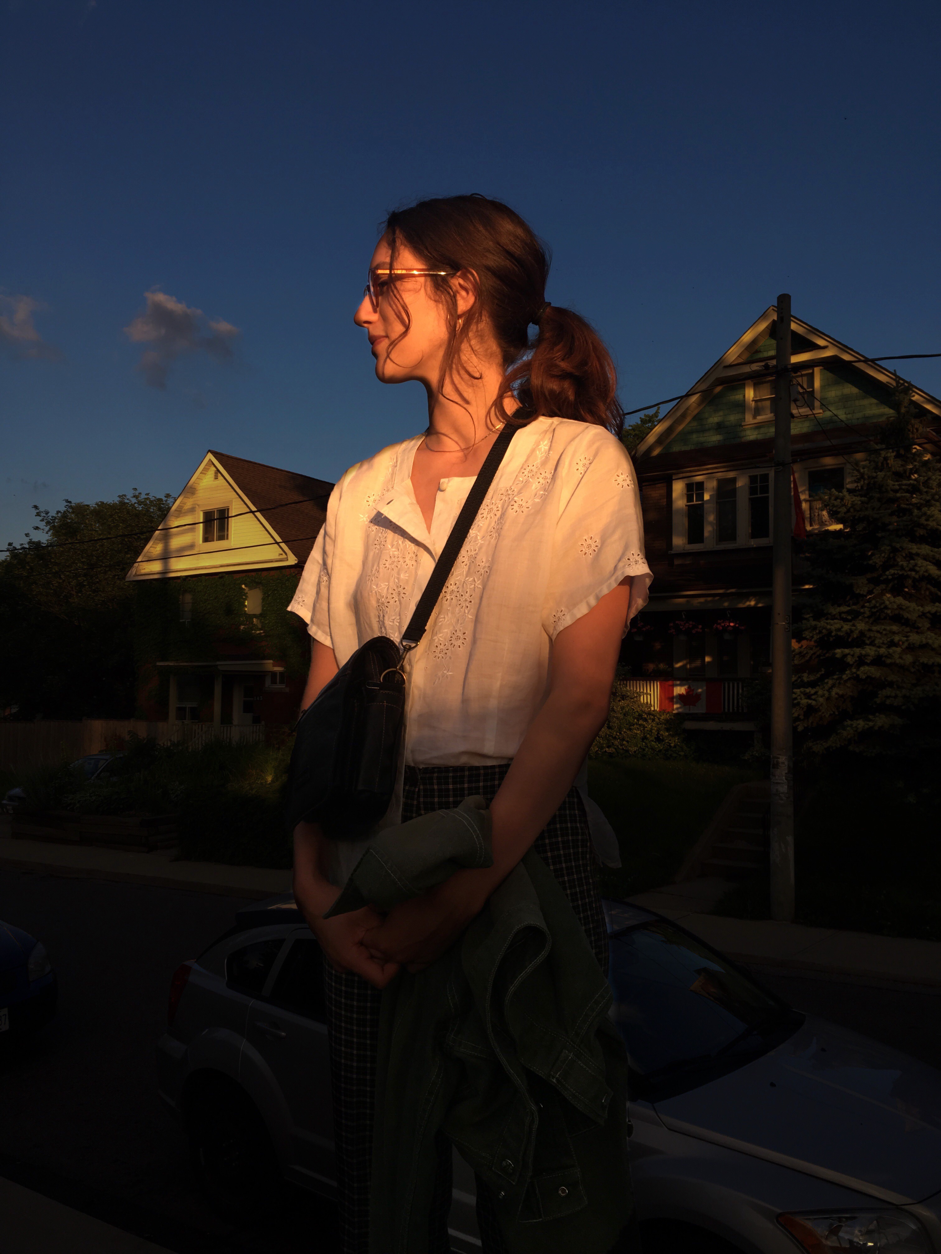 treme standing in sunlight in front of some houses