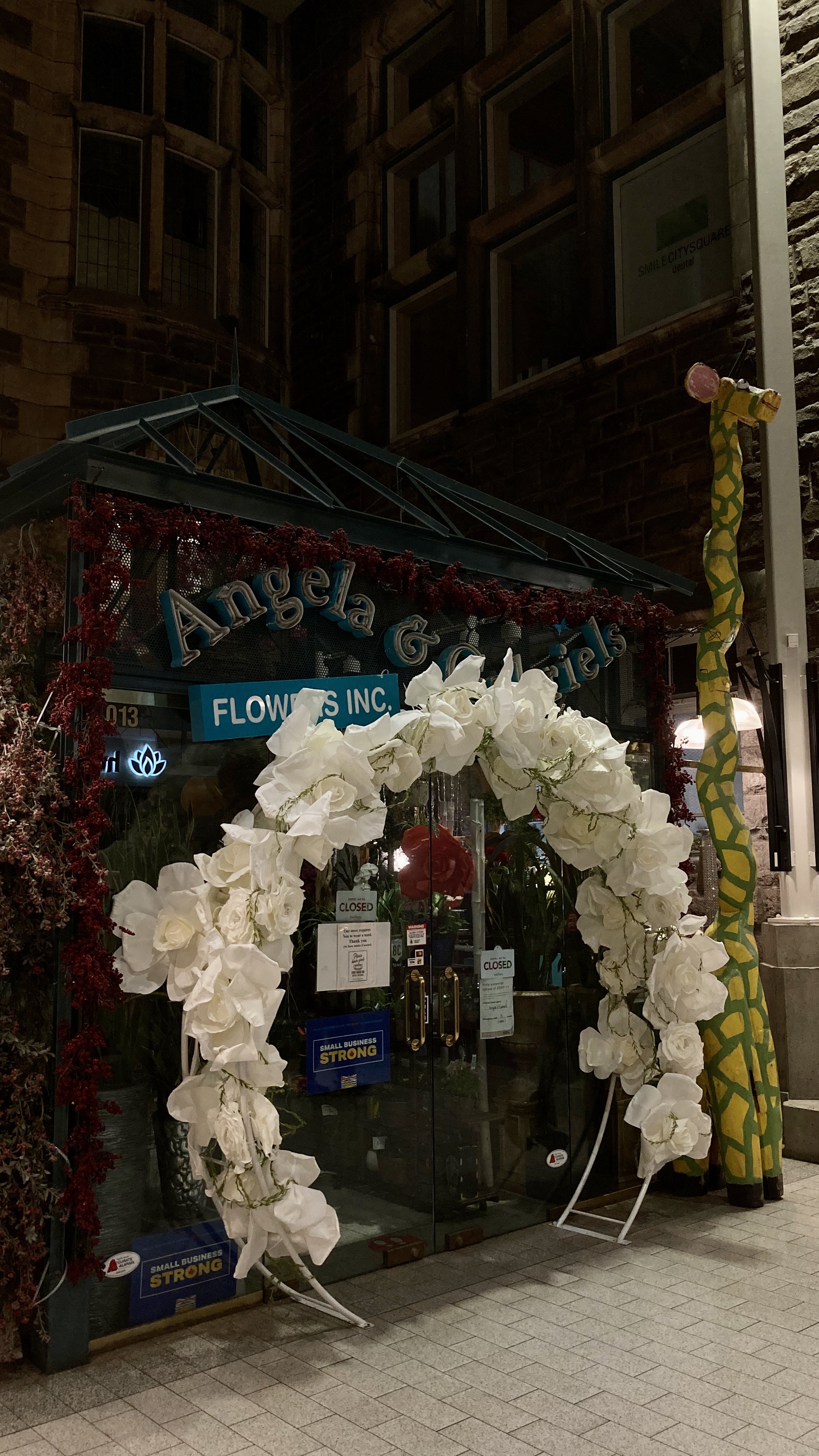 a flower stand with a silly giraffe in a mall, vancouver